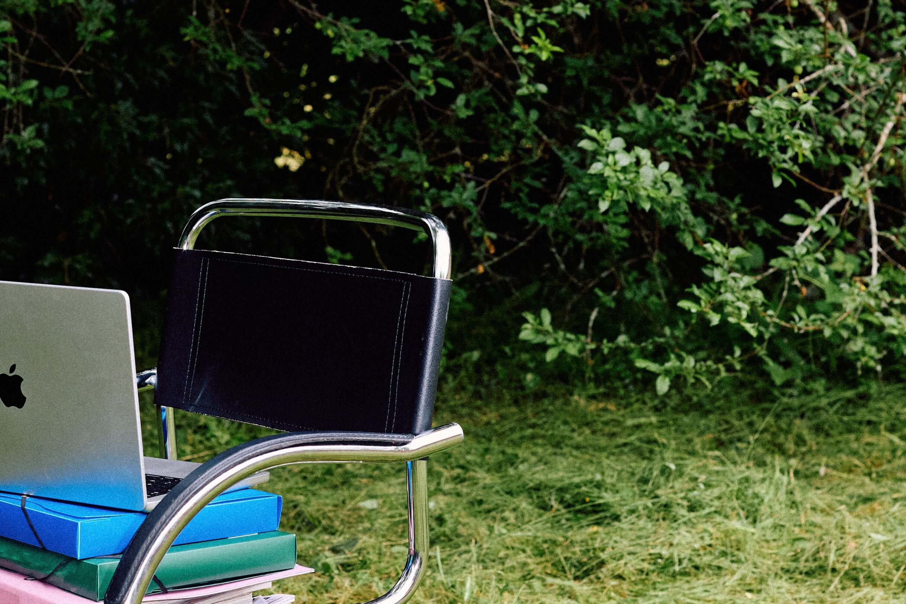 chaise dans un jardin avec des documents et un ordinateur portable