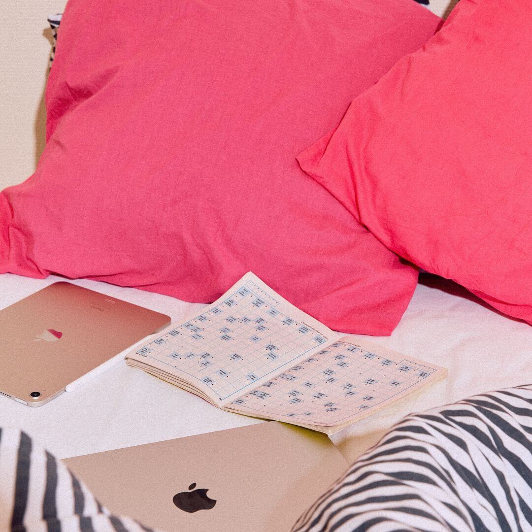 lit avec des mots fléchés, un ordinateur et une tablette