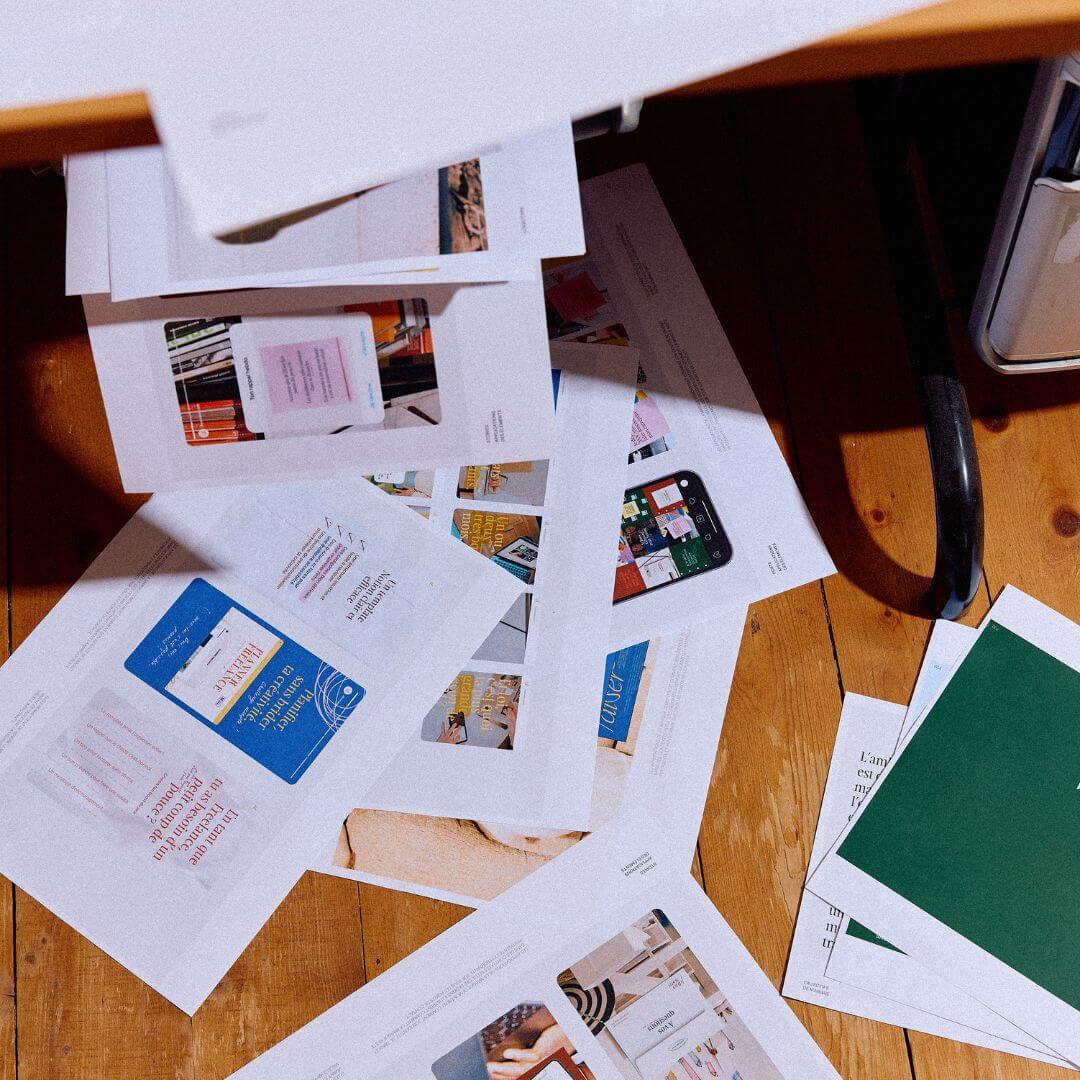 divers documents sortant d'une imprimante et tombant sur le sol