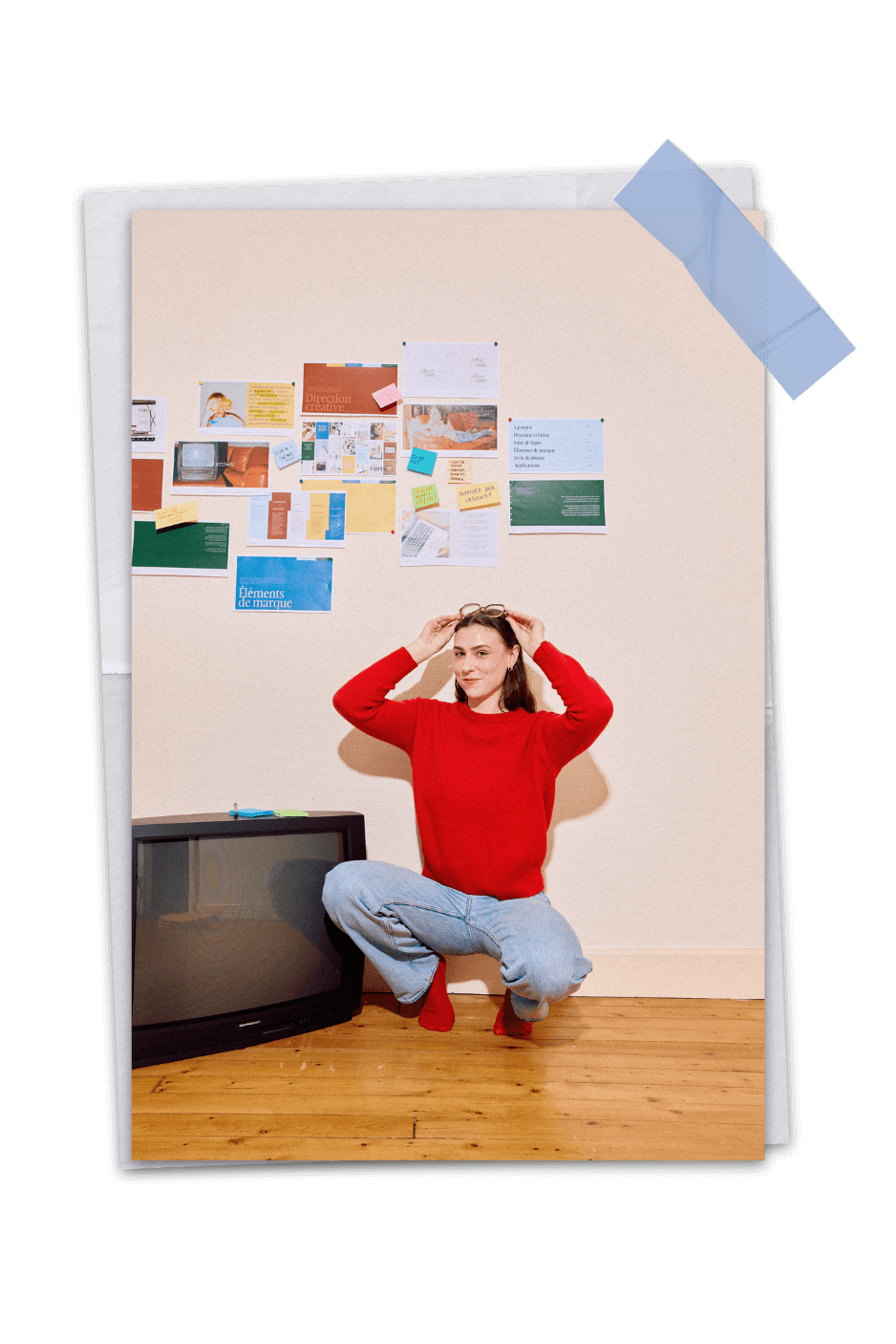 femme accroupie devant un mur avec des documents